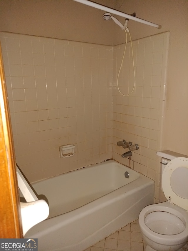 bathroom featuring tile patterned floors, toilet, and tiled shower / bath