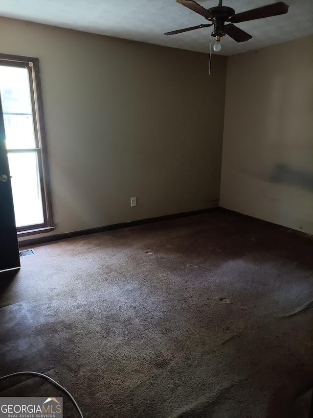 spare room with carpet flooring, ceiling fan, and plenty of natural light