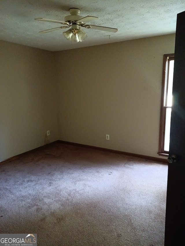 carpeted spare room featuring a textured ceiling