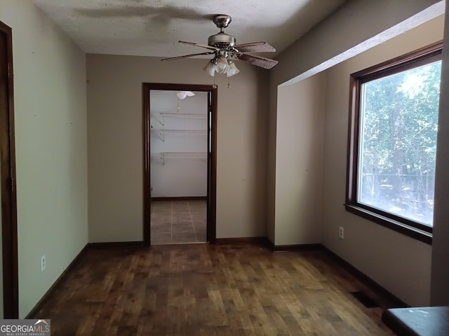 empty room with hardwood / wood-style flooring, ceiling fan, and a healthy amount of sunlight