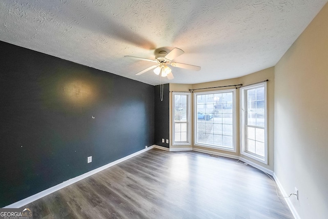 unfurnished room with hardwood / wood-style flooring, ceiling fan, and a textured ceiling