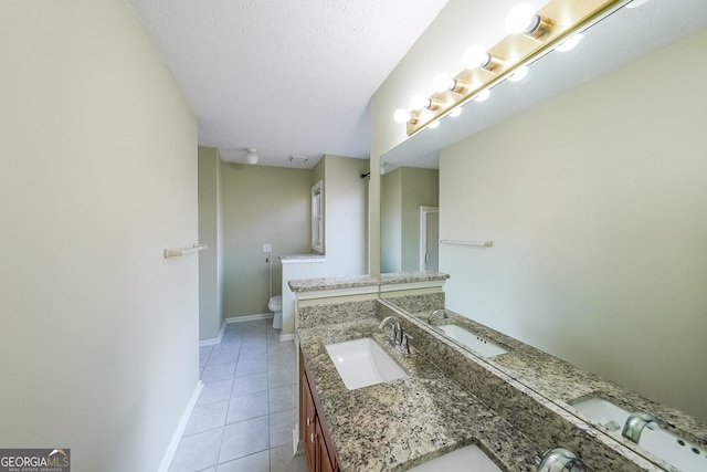 bathroom featuring tile patterned floors, vanity, toilet, and a textured ceiling