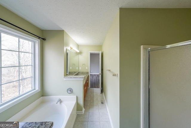 bathroom featuring plus walk in shower, a textured ceiling, vanity, and tile patterned flooring