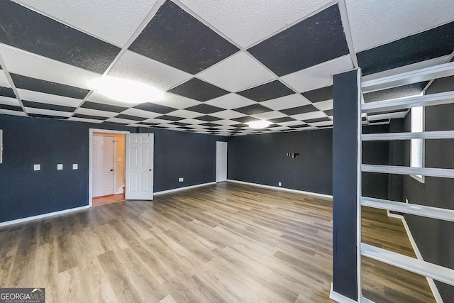 interior space featuring a drop ceiling and wood-type flooring