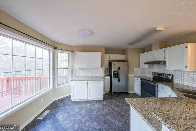 kitchen featuring decorative backsplash, light stone countertops, white cabinetry, and stainless steel appliances