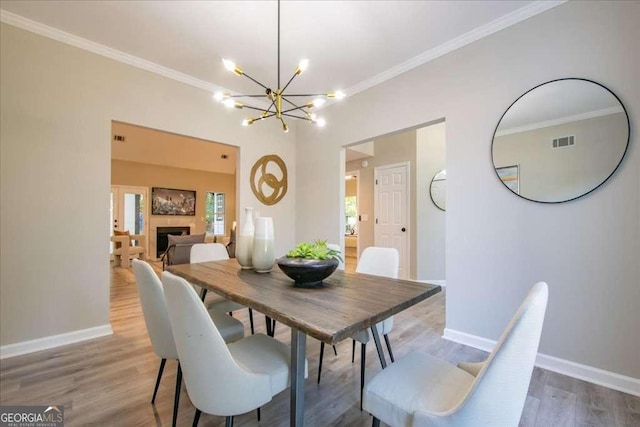 dining area featuring hardwood / wood-style flooring, an inviting chandelier, and ornamental molding