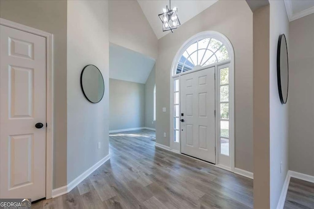 entryway featuring high vaulted ceiling, light hardwood / wood-style floors, and an inviting chandelier