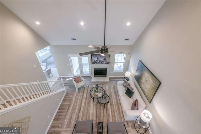 living room featuring hardwood / wood-style floors, ceiling fan, and vaulted ceiling