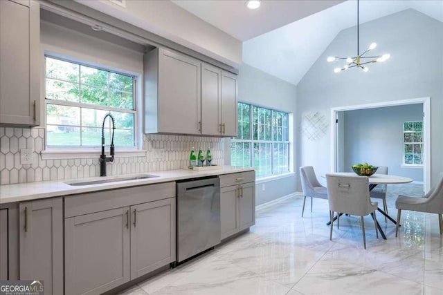 kitchen featuring gray cabinets, dishwasher, lofted ceiling, and sink