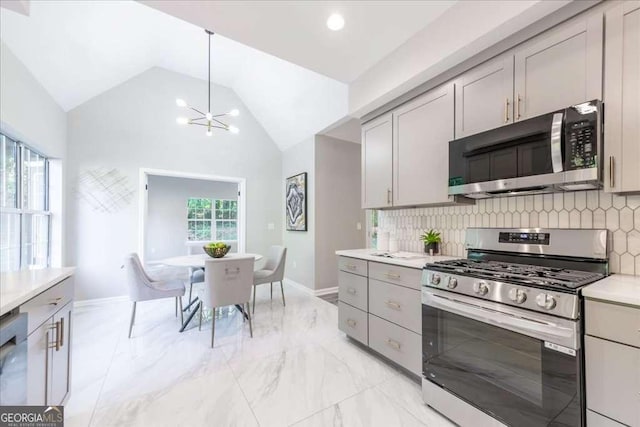 kitchen featuring gray cabinetry, backsplash, stainless steel appliances, and an inviting chandelier