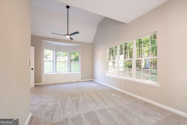 carpeted spare room featuring ceiling fan and vaulted ceiling