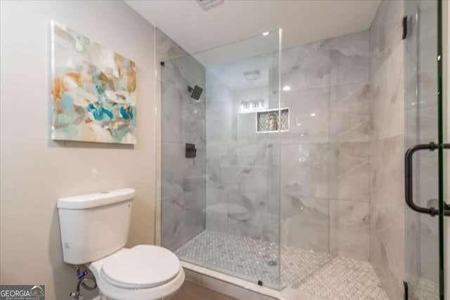 bathroom with an enclosed shower and toilet