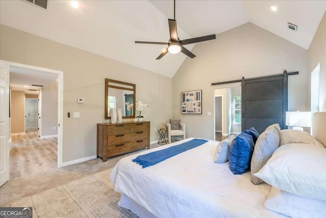 bedroom featuring ceiling fan, a barn door, and high vaulted ceiling