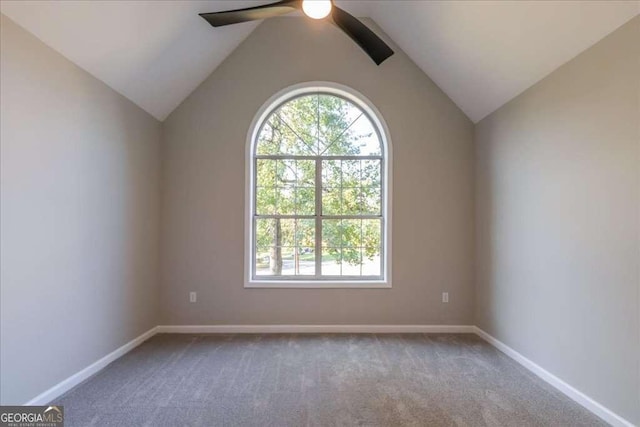 empty room featuring ceiling fan, lofted ceiling, and carpet floors