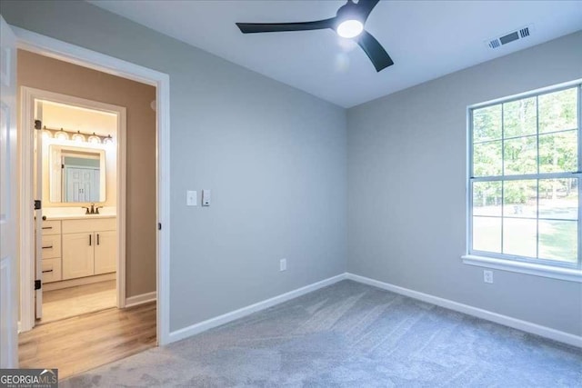 empty room with ceiling fan, sink, and light carpet