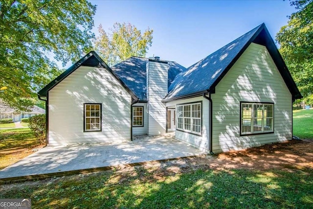 back of house with a yard and a patio