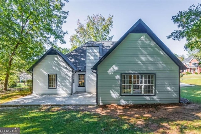 rear view of house with a lawn and a patio area