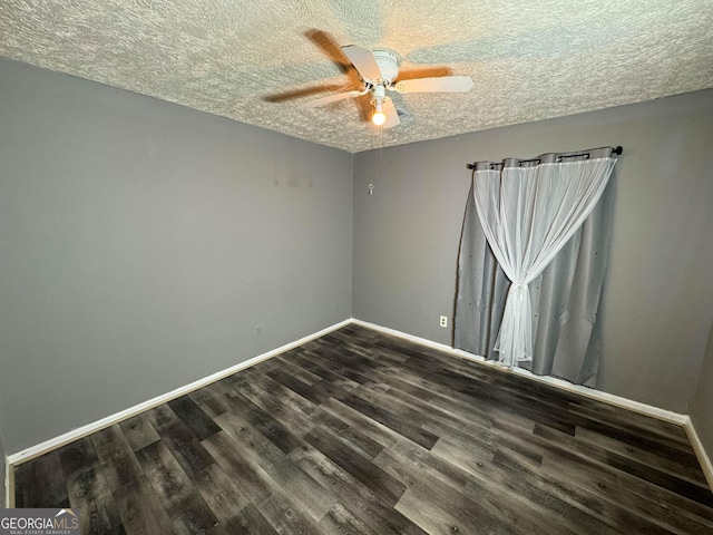 empty room with ceiling fan, dark hardwood / wood-style flooring, and a textured ceiling