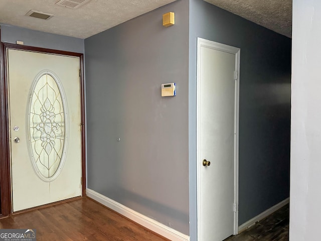 foyer entrance featuring dark hardwood / wood-style flooring and a textured ceiling