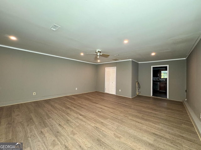 spare room featuring crown molding, ceiling fan, and light wood-type flooring