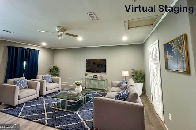 living room with hardwood / wood-style flooring, ceiling fan, and ornamental molding