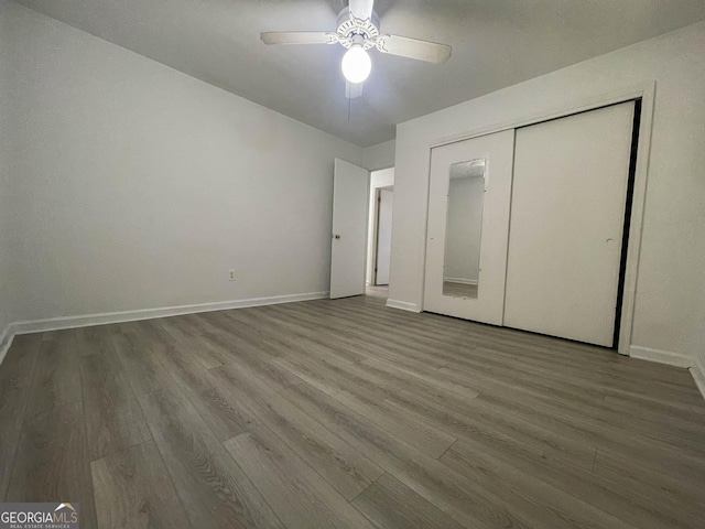 unfurnished bedroom featuring wood-type flooring, a closet, and ceiling fan