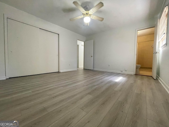 unfurnished bedroom with connected bathroom, ceiling fan, a closet, and light hardwood / wood-style flooring