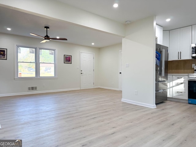 unfurnished living room featuring ceiling fan and light wood-type flooring