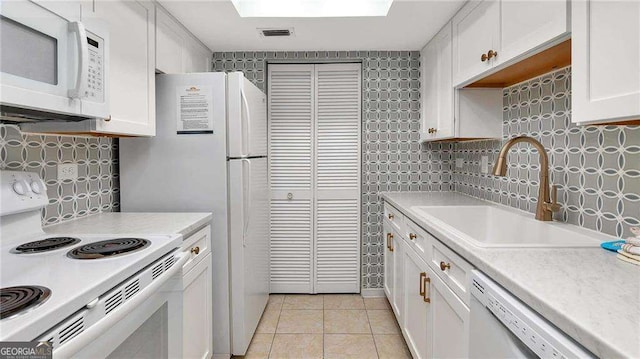 kitchen featuring white cabinetry, sink, white appliances, decorative backsplash, and light tile patterned flooring