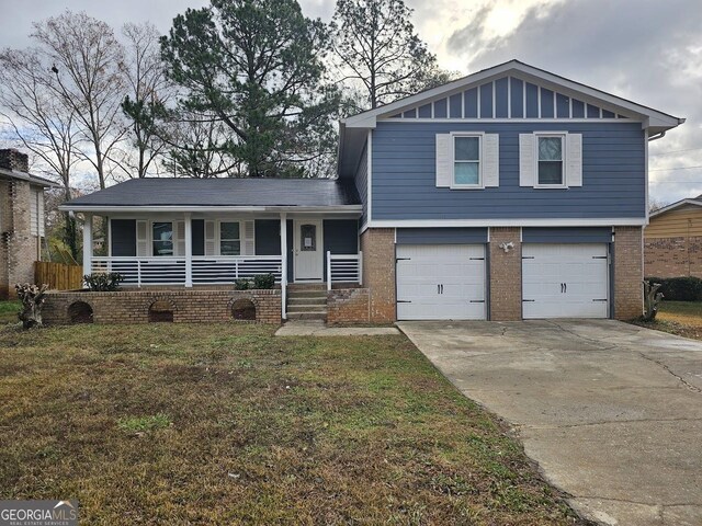 view of front facade with covered porch, a garage, and a front yard