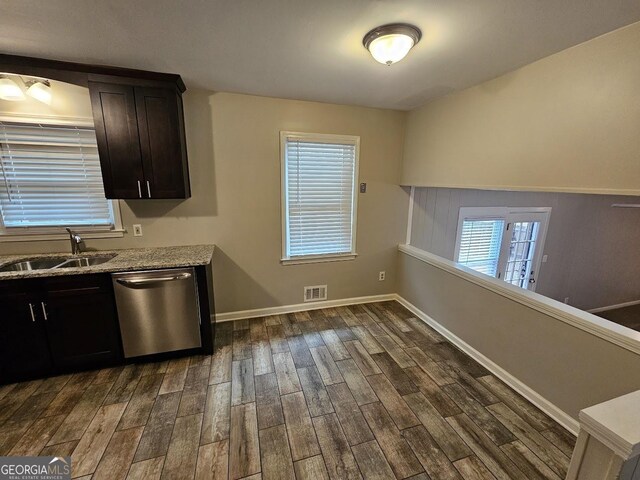 kitchen featuring dark hardwood / wood-style flooring, light stone counters, dark brown cabinets, sink, and dishwasher