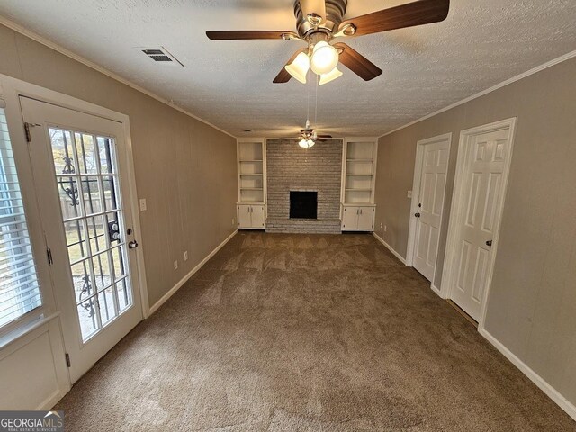 unfurnished living room featuring dark carpet, a brick fireplace, a textured ceiling, and built in features