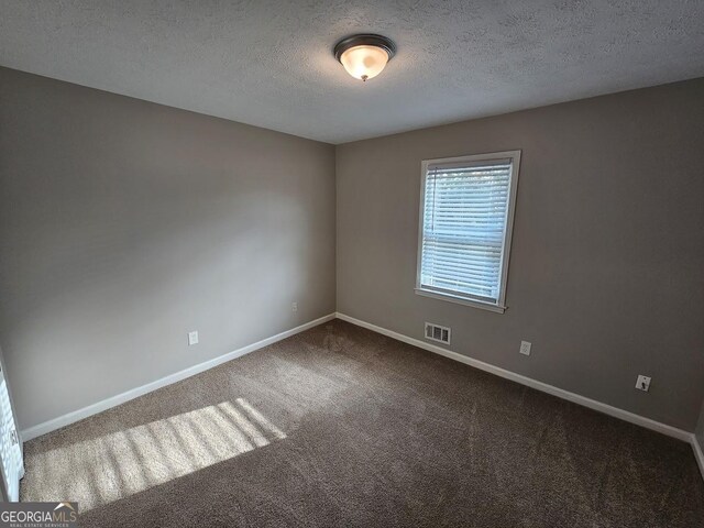 empty room featuring carpet floors and a textured ceiling