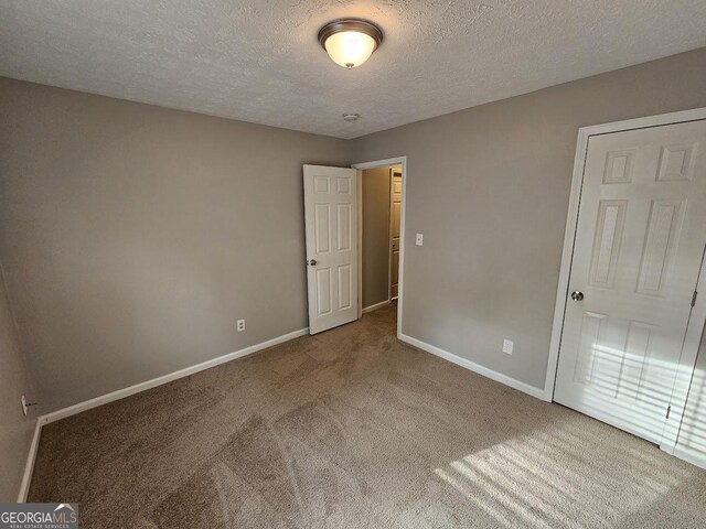 unfurnished bedroom with carpet and a textured ceiling