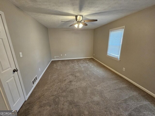 carpeted spare room featuring ceiling fan and a textured ceiling