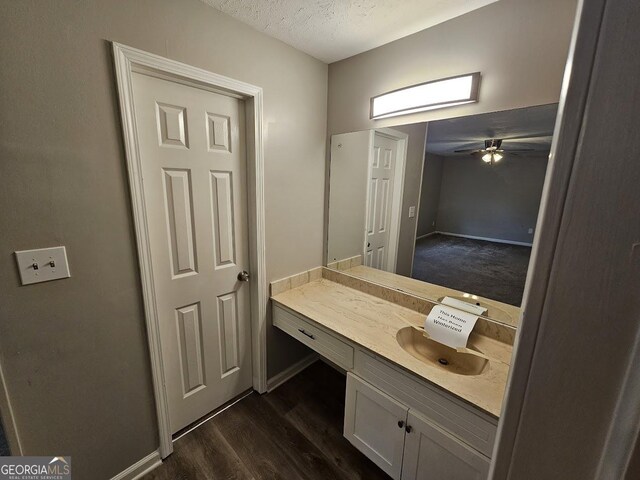 bathroom featuring vanity, a textured ceiling, hardwood / wood-style flooring, and ceiling fan