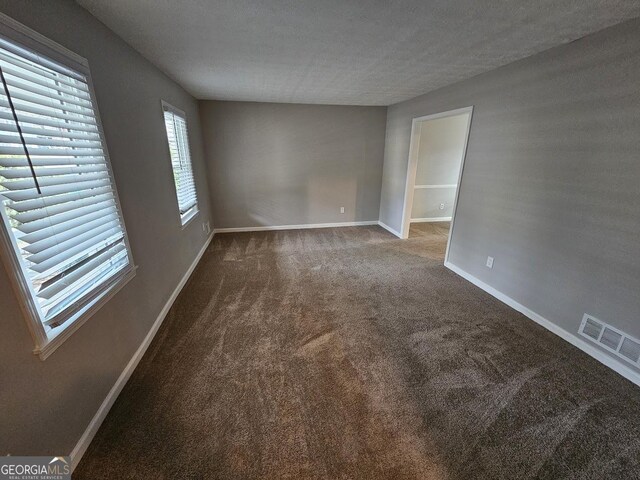 carpeted spare room featuring a textured ceiling