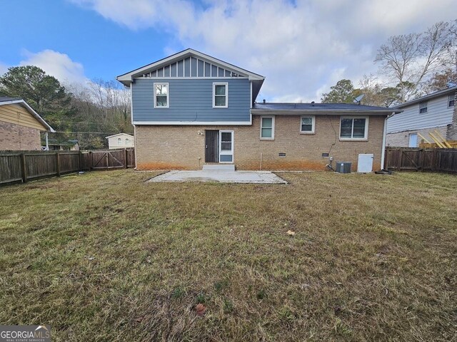 back of house featuring central AC unit, a patio area, and a yard