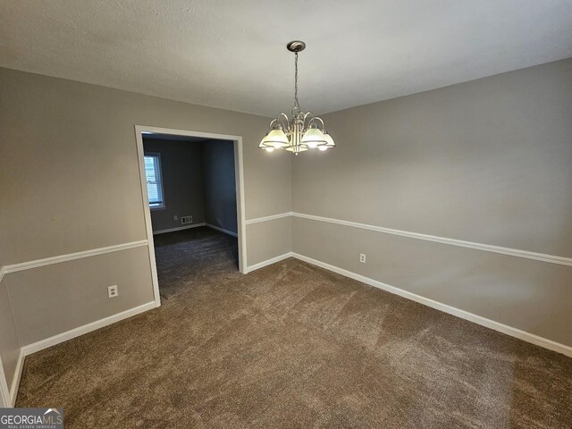 unfurnished dining area featuring dark colored carpet and an inviting chandelier