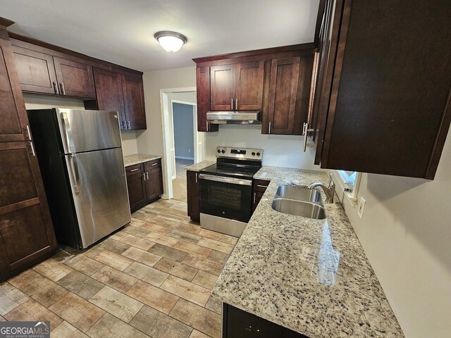 kitchen featuring light stone counters, sink, dark brown cabinets, and stainless steel appliances