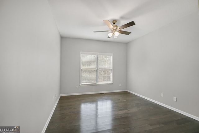 spare room featuring ceiling fan and dark wood-type flooring