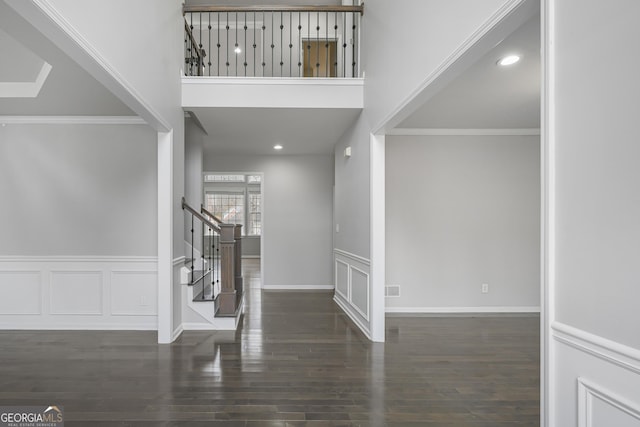 entryway with crown molding and dark wood-type flooring