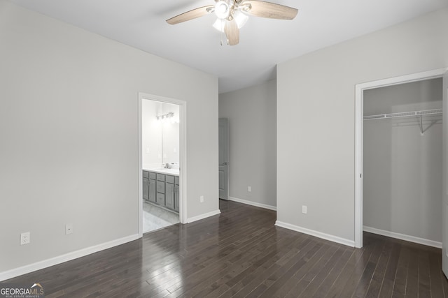 unfurnished bedroom featuring a closet, dark hardwood / wood-style floors, ensuite bath, and ceiling fan