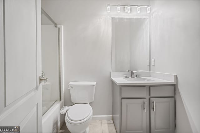 full bathroom with shower / bath combination with glass door, tile patterned flooring, vanity, and toilet