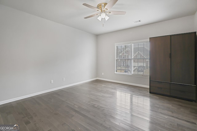 unfurnished bedroom featuring dark hardwood / wood-style floors and ceiling fan