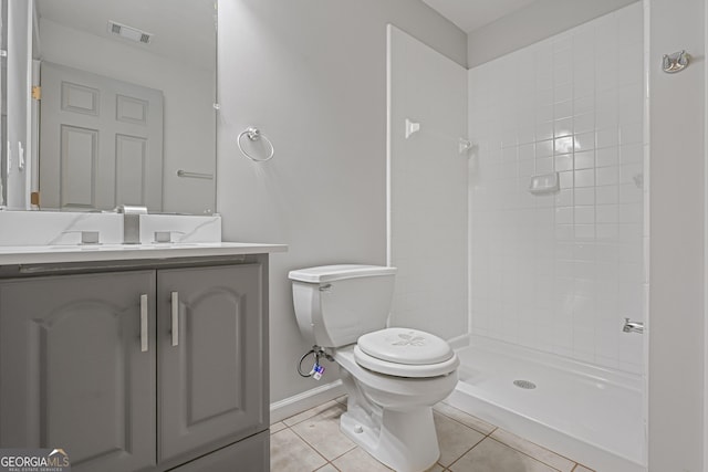 bathroom featuring toilet, vanity, tile patterned floors, and walk in shower