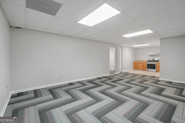 basement featuring dark carpet and a drop ceiling