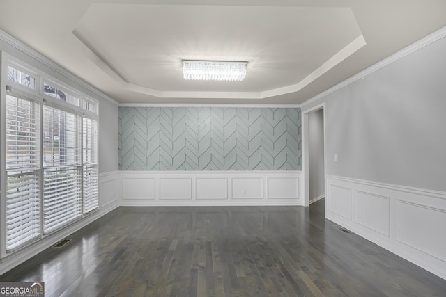 unfurnished room with crown molding, dark wood-type flooring, and a tray ceiling