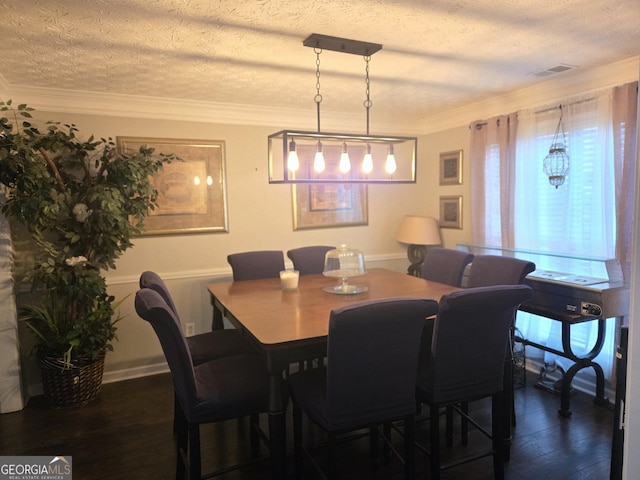 dining area with a textured ceiling, crown molding, and dark hardwood / wood-style floors