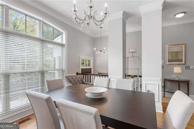 dining area featuring hardwood / wood-style flooring, an inviting chandelier, and crown molding